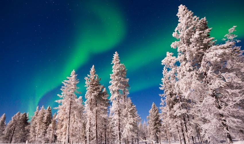 Beautiful Northern Lights display over snowy landscape in Lapland, Finland at night