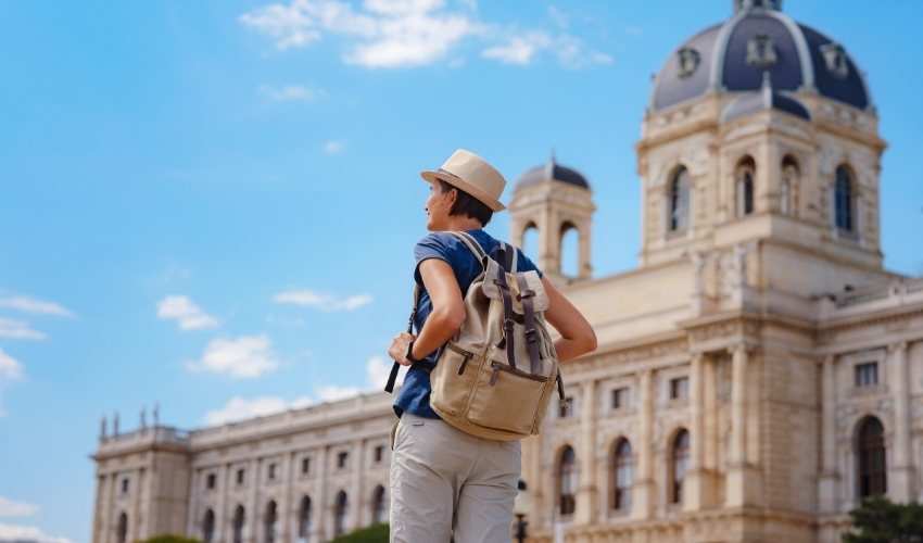 Happy young woman on a summer trip walking along a European street