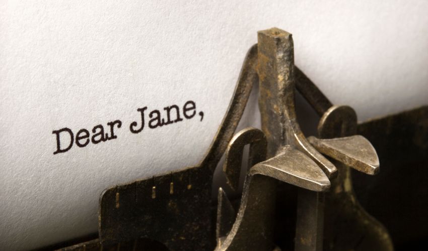 Close-up of a vintage typewriter with the words Dear Jane typed on white paper