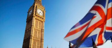 The Big Ben clock tower in London with a blurred Union Jack flag in the foreground
