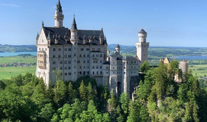 Scenic view of Neuschwanstein Castle in Bavarian landscape with blue sky