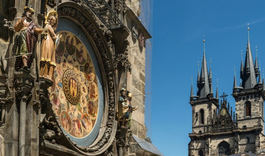 Close-up of the Prague Astronomical Clock with Church of Our Lady before Týn in the background.