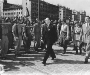 WW2 military leader walking past troops during wartime gathering